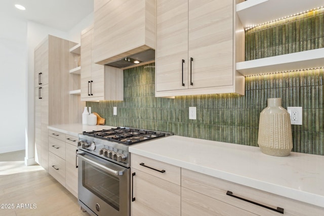 kitchen with tasteful backsplash, high end stainless steel range, custom exhaust hood, and light brown cabinets