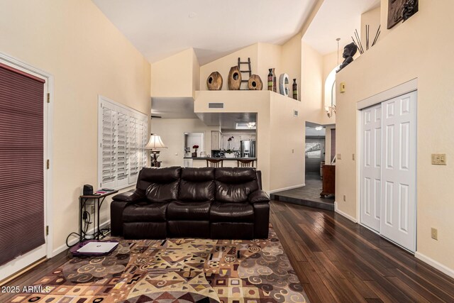 living area featuring baseboards, high vaulted ceiling, and dark wood-style flooring