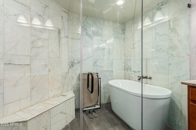 full bath with a shower stall, a freestanding tub, vanity, and tile walls