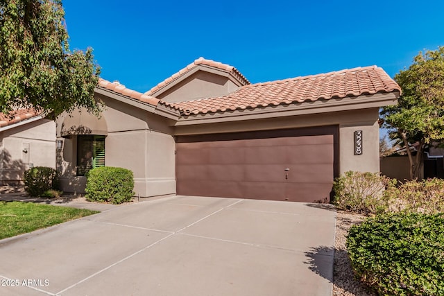 mediterranean / spanish-style house featuring a garage, driveway, a tile roof, and stucco siding