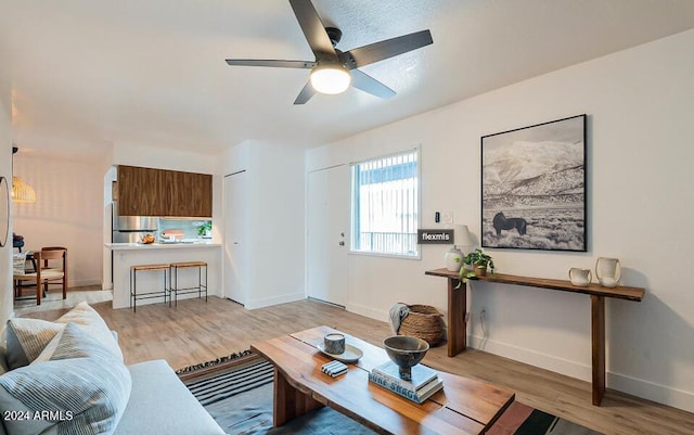 living room with light wood-type flooring and ceiling fan