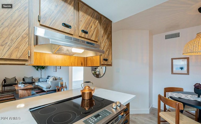 kitchen with light hardwood / wood-style floors and stainless steel range with electric cooktop