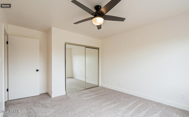 unfurnished bedroom featuring a closet, light colored carpet, and ceiling fan