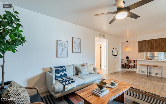 living room featuring light wood-type flooring and ceiling fan