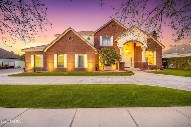 view of front facade with a yard and brick siding