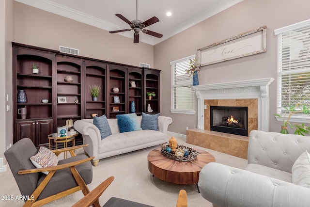 living room featuring baseboards, visible vents, a premium fireplace, ornamental molding, and recessed lighting