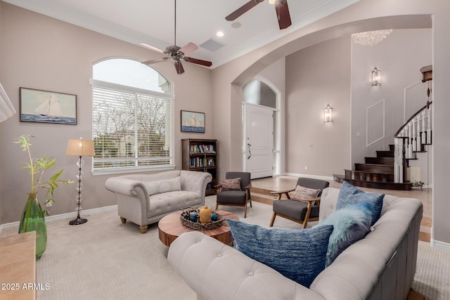 living room with arched walkways, ornamental molding, stairway, and baseboards