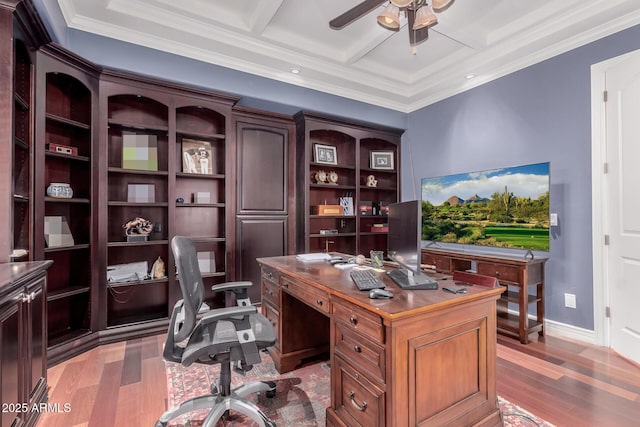 office space featuring ceiling fan, coffered ceiling, baseboards, ornamental molding, and light wood finished floors