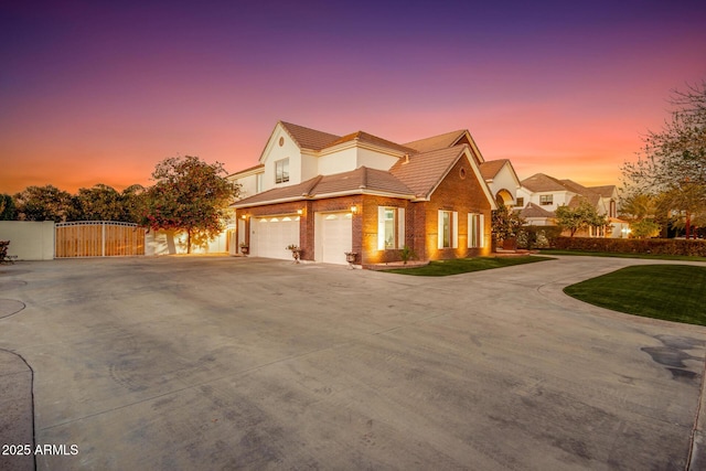 view of front facade featuring a garage, a gate, driveway, and fence