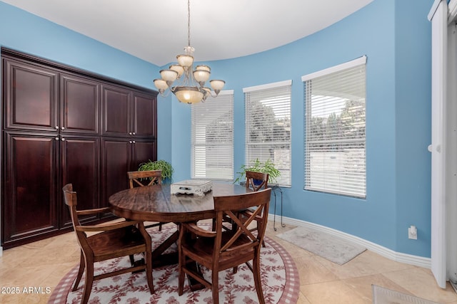 dining area with a notable chandelier, baseboards, and light tile patterned floors