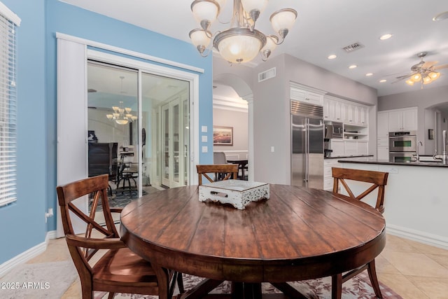 dining space featuring arched walkways, ceiling fan with notable chandelier, visible vents, and recessed lighting