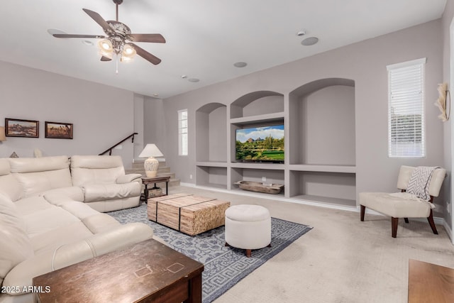 living area with baseboards, a healthy amount of sunlight, carpet, and built in features