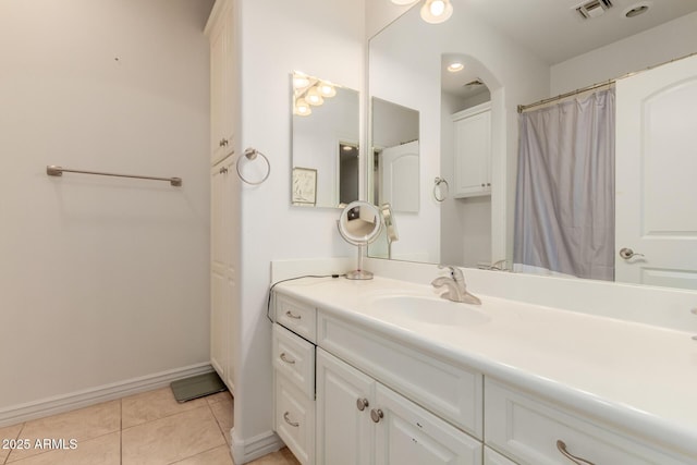 bathroom with tile patterned flooring, visible vents, vanity, and baseboards