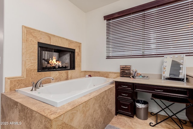 bathroom with tile patterned flooring, a bath, and a lit fireplace