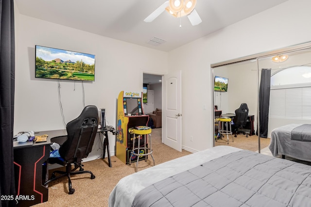 bedroom with baseboards, visible vents, a ceiling fan, light colored carpet, and a closet