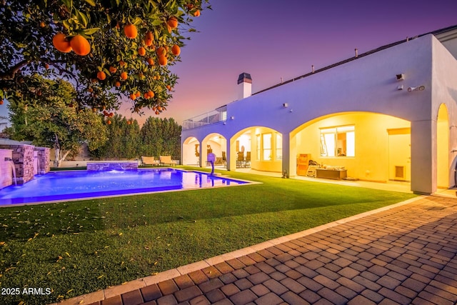 outdoor pool with a patio area, a yard, and fence