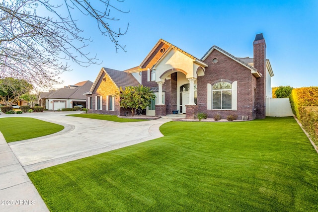 view of front of property featuring brick siding, a chimney, a front yard, fence, and driveway