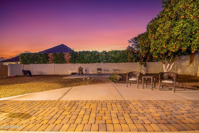 patio terrace at dusk with a fenced backyard