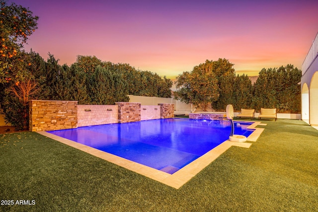 outdoor pool featuring a lawn and a fenced backyard