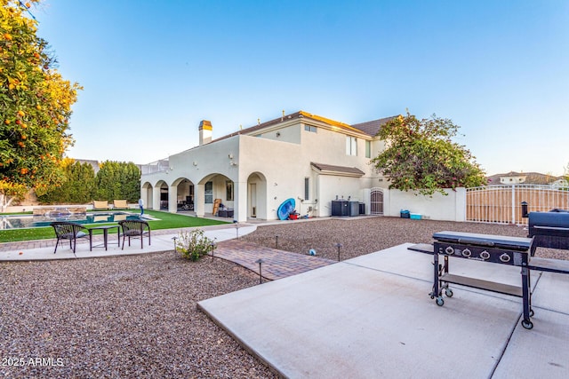 exterior space with a patio, cooling unit, fence, a pool, and stucco siding