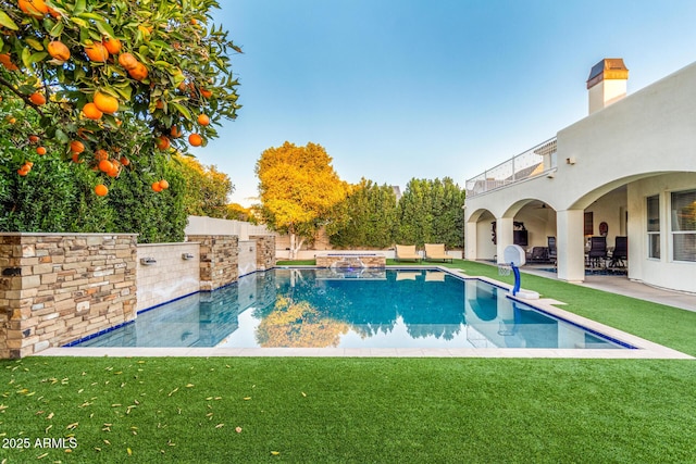 view of pool featuring a patio area, a fenced backyard, a pool with connected hot tub, and a yard