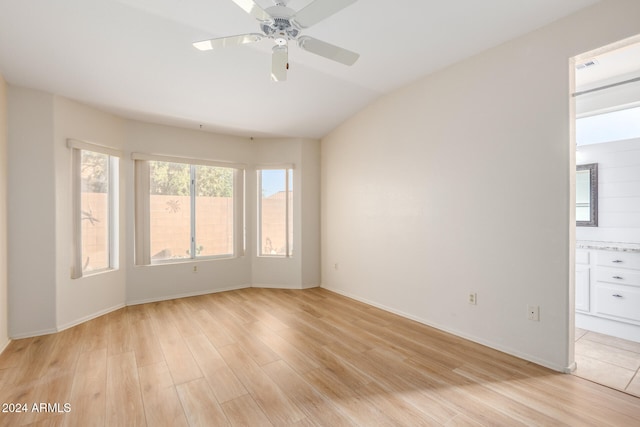 empty room featuring ceiling fan, light wood-type flooring, and vaulted ceiling