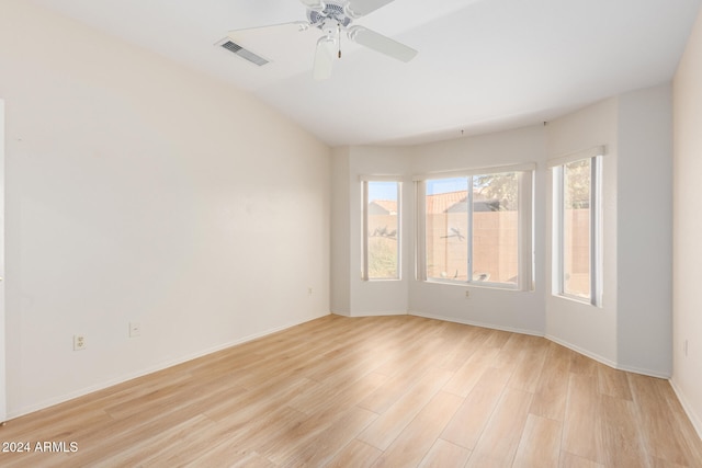 empty room with ceiling fan and light hardwood / wood-style flooring