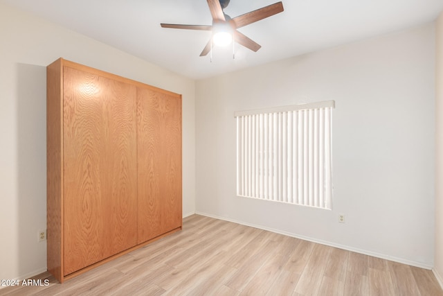 unfurnished bedroom featuring ceiling fan, light hardwood / wood-style flooring, and a closet