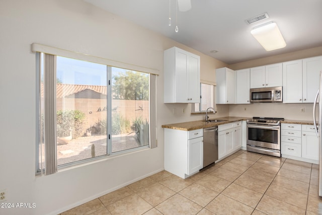 kitchen with white cabinets, stainless steel appliances, a wealth of natural light, and sink