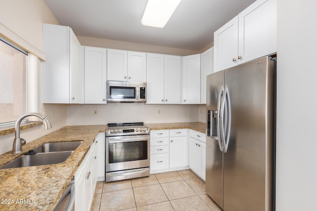 kitchen with light stone countertops, sink, white cabinets, and stainless steel appliances