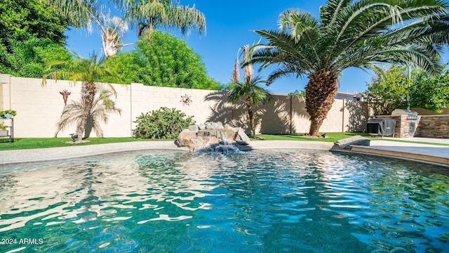 view of pool featuring an outdoor kitchen and pool water feature