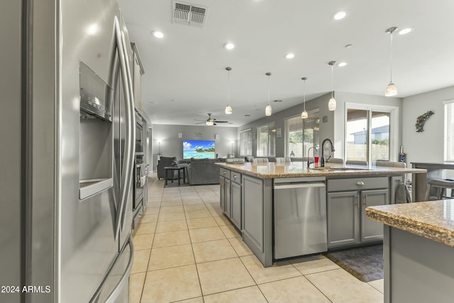 kitchen with appliances with stainless steel finishes, ceiling fan, sink, pendant lighting, and gray cabinets