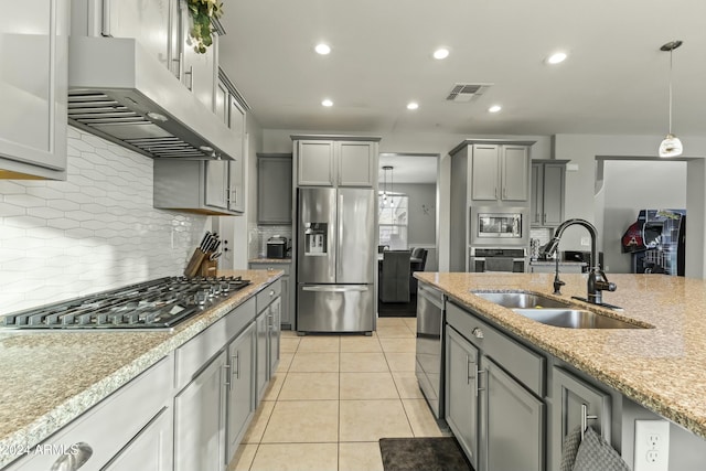 kitchen with decorative backsplash, appliances with stainless steel finishes, gray cabinetry, sink, and decorative light fixtures