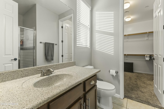 bathroom featuring tile patterned flooring, vanity, an enclosed shower, and toilet