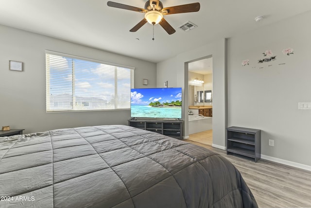 bedroom featuring ceiling fan, light wood-type flooring, and ensuite bath