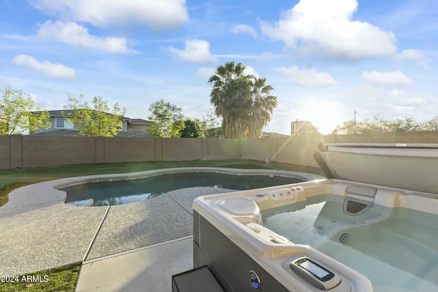 view of swimming pool with a hot tub