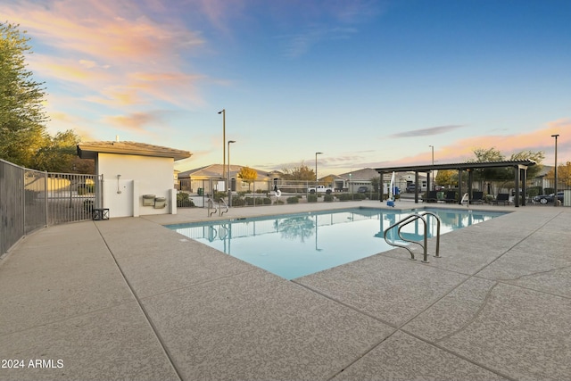 pool at dusk featuring a patio