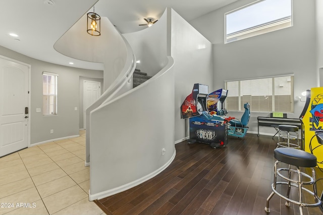 entrance foyer featuring a wealth of natural light, ceiling fan, a towering ceiling, and hardwood / wood-style flooring