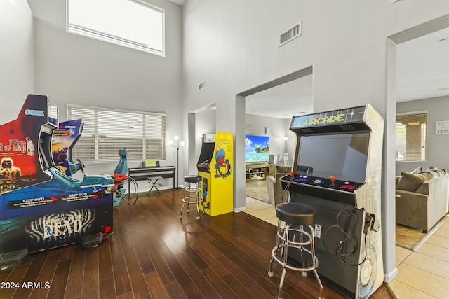 recreation room with wood-type flooring and a high ceiling