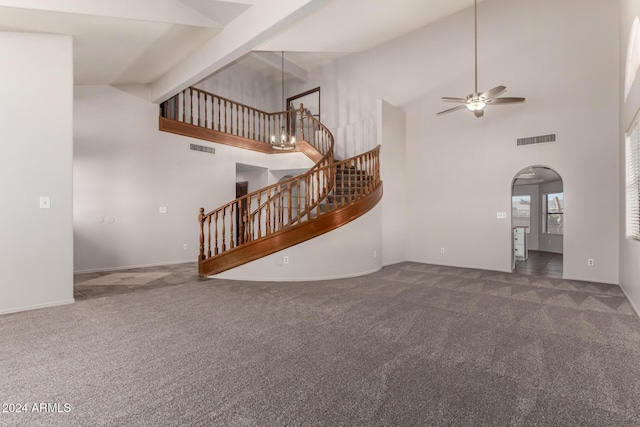 unfurnished living room with dark colored carpet, ceiling fan, beamed ceiling, and high vaulted ceiling