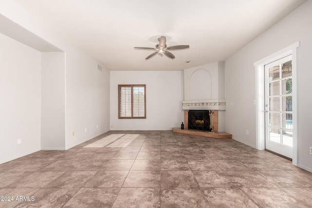 unfurnished living room with ceiling fan and a fireplace