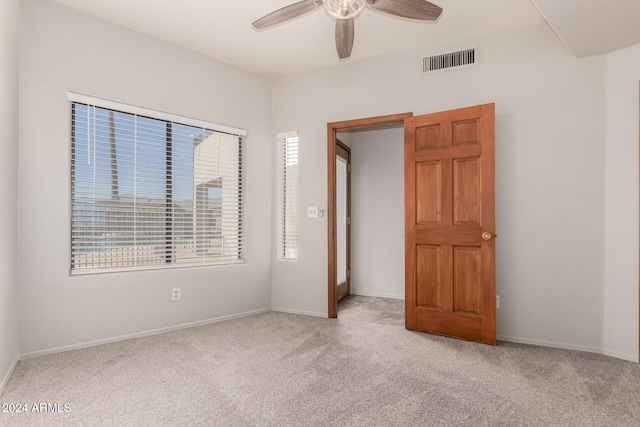 unfurnished bedroom featuring light carpet and ceiling fan