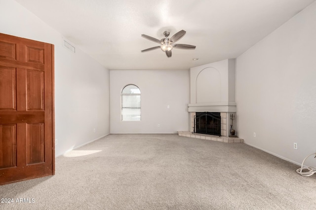 unfurnished living room featuring a fireplace, carpet, and ceiling fan