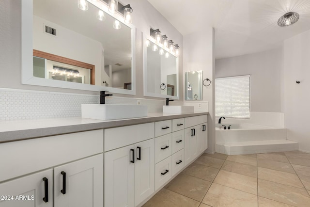 bathroom featuring decorative backsplash, vanity, a tub to relax in, and tile patterned floors