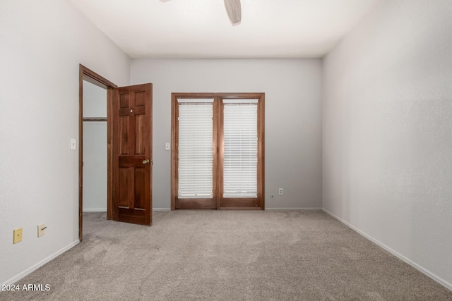 spare room with ceiling fan and light colored carpet