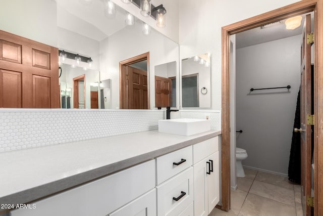 bathroom featuring tile patterned flooring, vanity, toilet, and tasteful backsplash