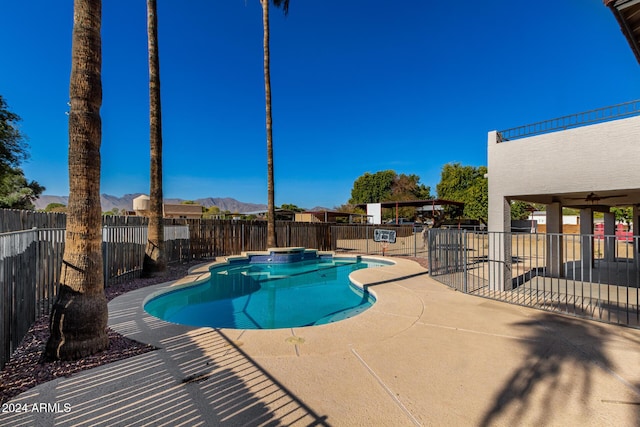 view of swimming pool featuring a mountain view, a patio, and ceiling fan