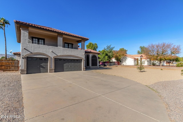 mediterranean / spanish-style house featuring a garage and a balcony