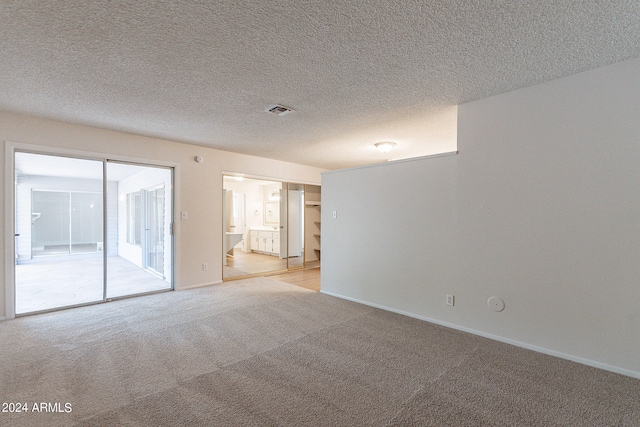 carpeted spare room with a textured ceiling