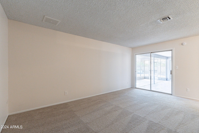 carpeted spare room with a textured ceiling